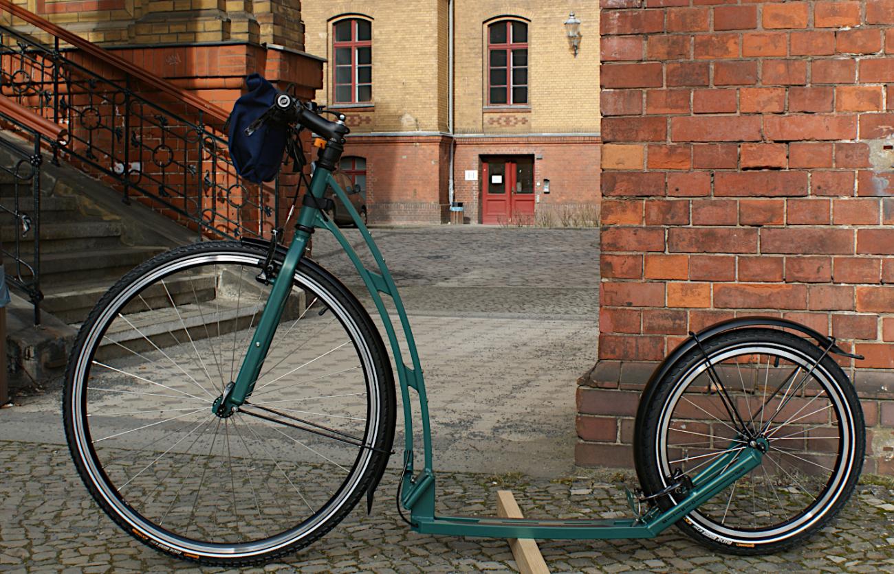 Tretroller MIBO SPLIT 28 vor Architektur aus Sichtmauerwerk